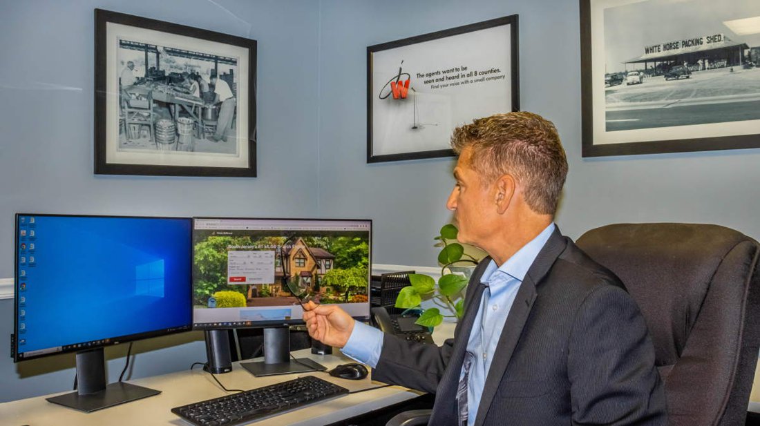 Joe Wiessner at his desk, with historical South Jersey farm photos on the wall