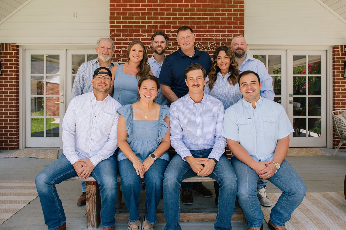 The Todd Tramonte Home Selling Team gathered in front of a brick building in Dallas-Fort Worth