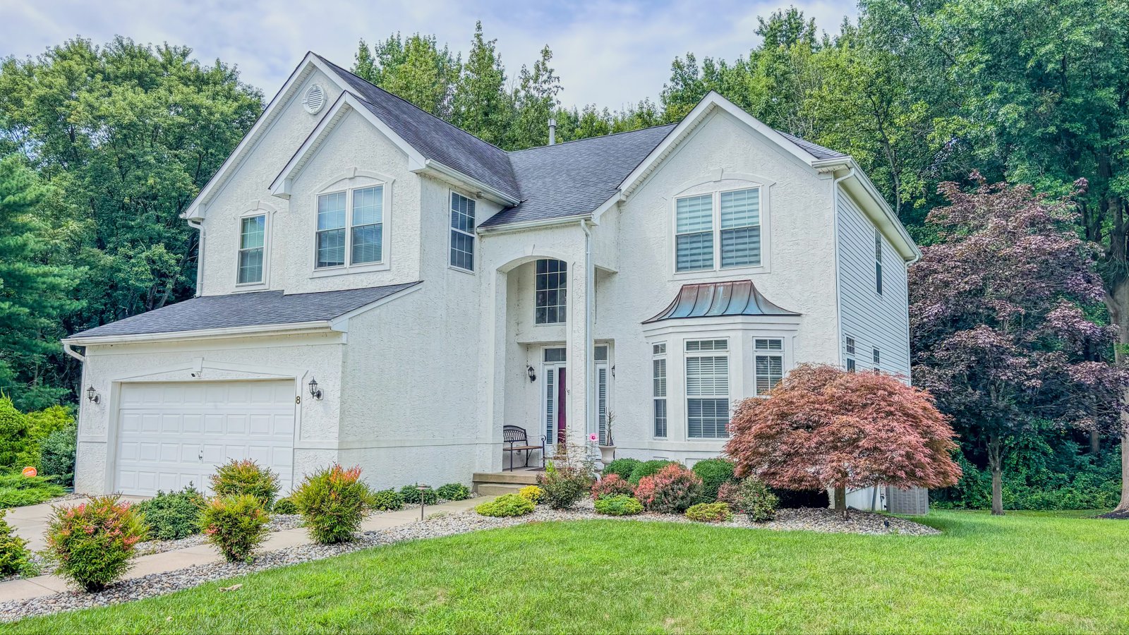 Two-story colonial home with a landscaped front yard in South Jersey
