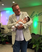 Realtor Don Shurts dedicating a child in church