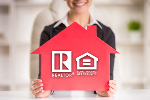 Agent holding a sign with a realtor logo