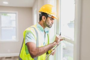 A man in a yellow vest inspecting a house