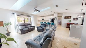 Open living room and updated kitchen overlooking the screened pool at 2461 Gold Oak Ct E
