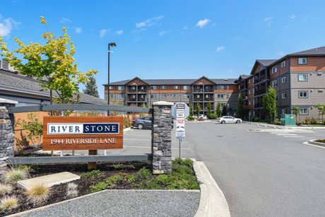 Top-floor condo at #415 1944 Riverside Lane in Courtenay featuring Mt. Washington views, quartz countertops, stainless steel appliances, bright open-concept living, and walkable access to downtown amenities and the riverside pathway.