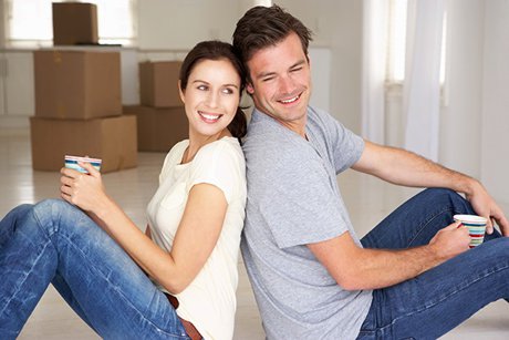 Couple resting after moving boxes into a home. 