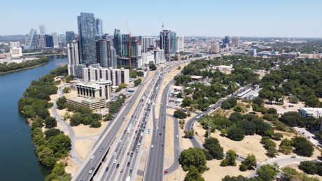 Austin Texas skyline with highway traffic showing commute route from suburbs like Buda and Kyle into downtown