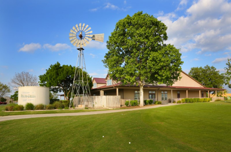 Plum Creek golf course community in Kyle Texas with clubhouse windmill and neighborhood homes