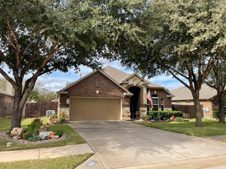 Single-story brick home in Whispering Hollow neighborhood in Buda TX