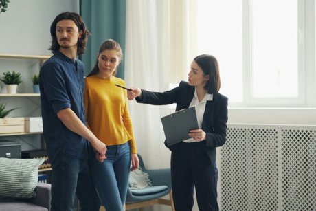 Real estate agent showing a couple around the interior of a house