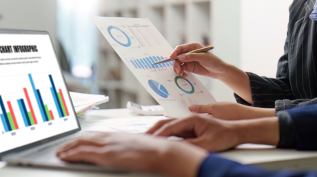 Real estate market report and charts on a laptop