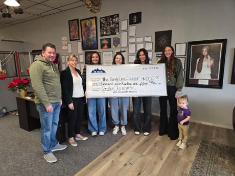 Jordan Cherrington and Carolyn Canning present Rexburg Family Crisis Center with a donation from UVAR