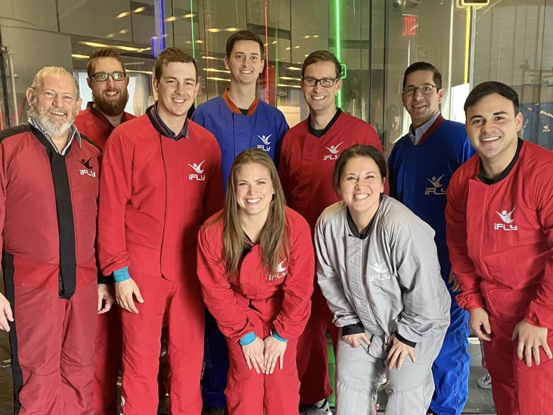 Todd Tramonte Home Selling Team members in flight suits at an indoor skydiving outing