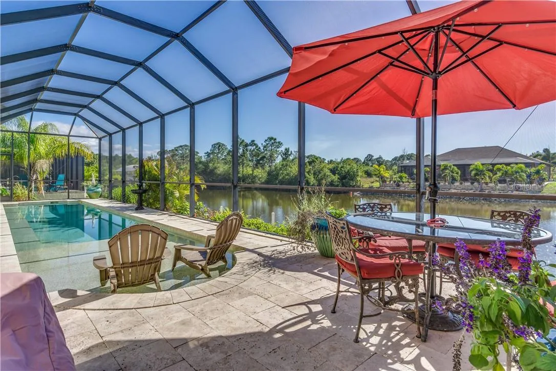Screened swimming pool and outdoor living area overlooking a South Gulf Cove canal