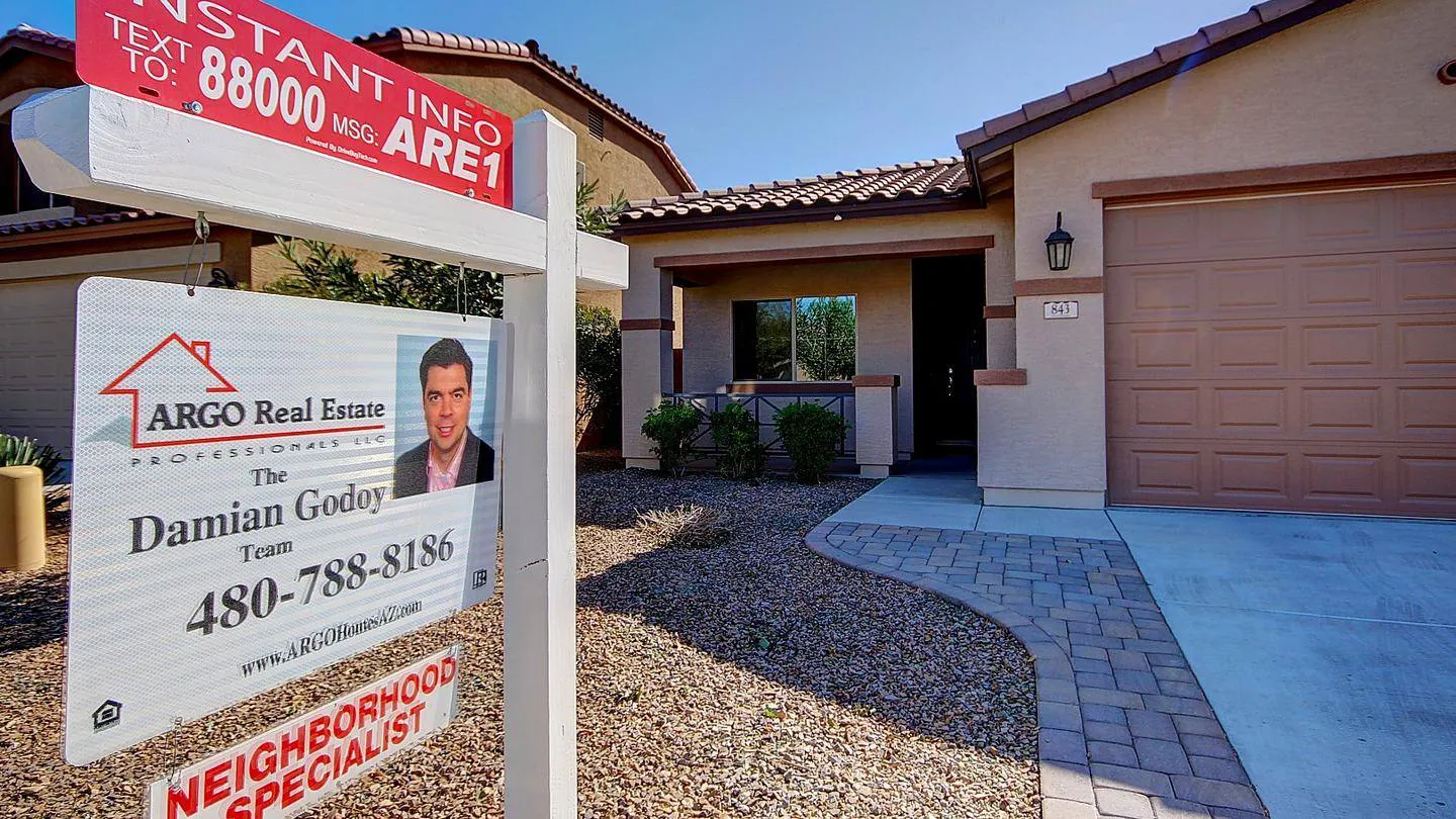 ARGO Real Estate yard sign with Damian Godoy in front of a Southeast Valley home