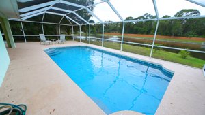 The expansive pool area overlooks a quiet lake