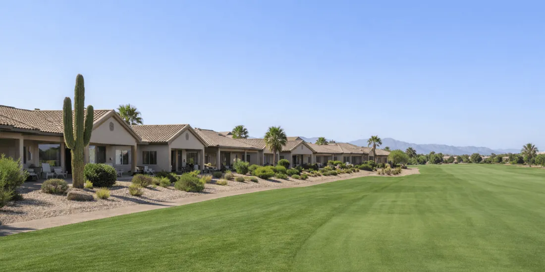 Single-story homes in a Phoenix 55+ community backing to a golf course with desert landscaping and mountain views
