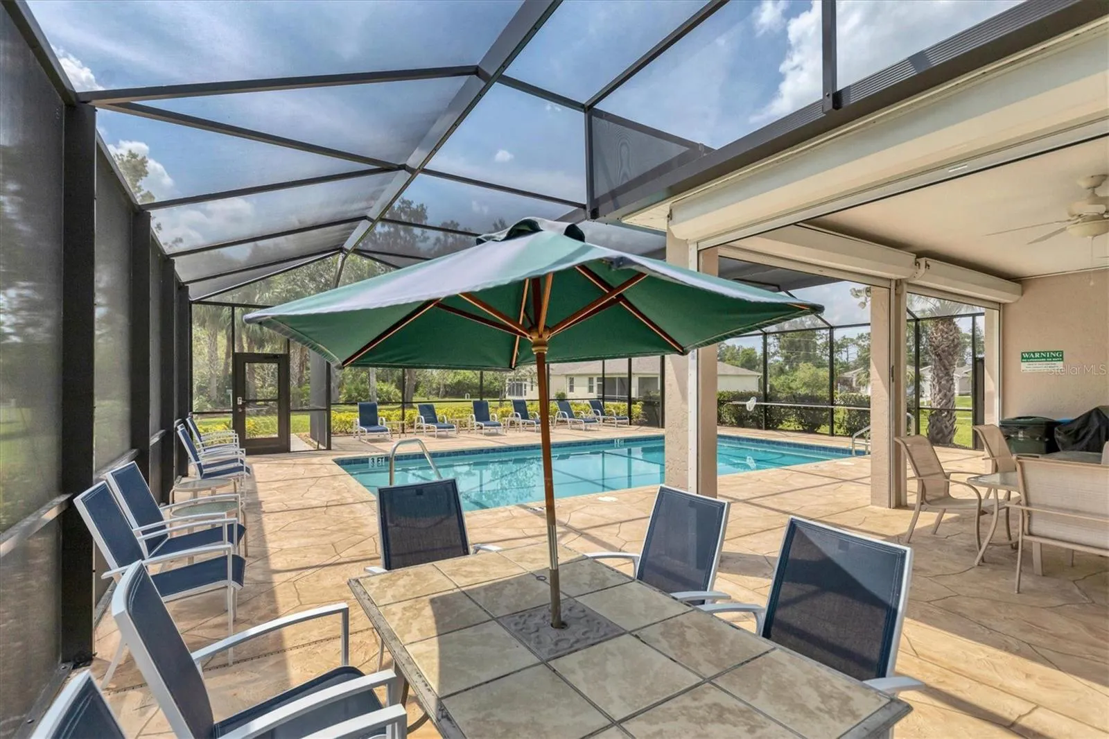 Woodhaven Estates pool patio seating and shaded tables