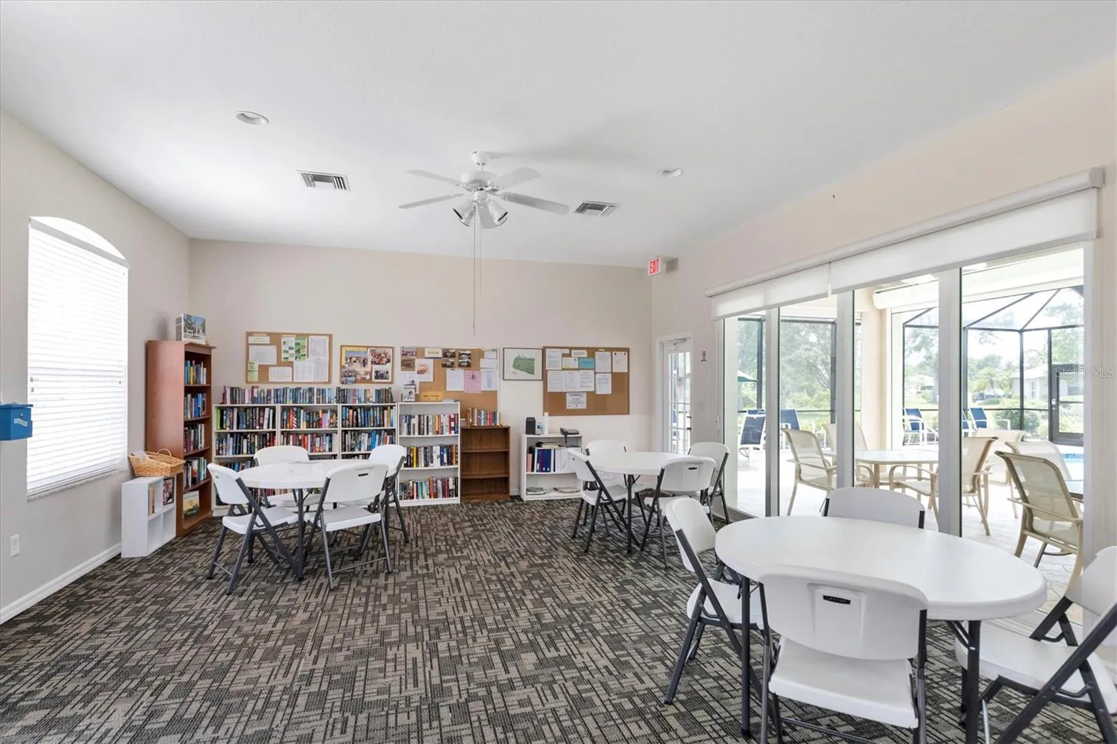Woodhaven Estates Villas clubhouse community room with tables and books